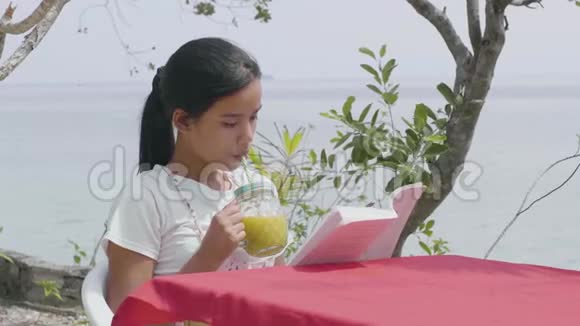 一个有压力空闲时间的女人在看书时享受冷茶点视频的预览图