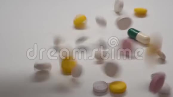 大量不同种类的药丸缓慢地落在白色背景上视频的预览图