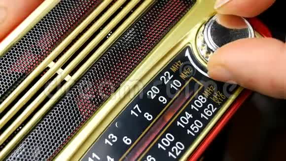 人类用手指把旧收音机调到无线电波打开旋钮寻找有趣的电台视频的预览图