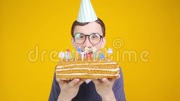生日快乐带着橙色背景的蛋糕的年轻人视频的预览图