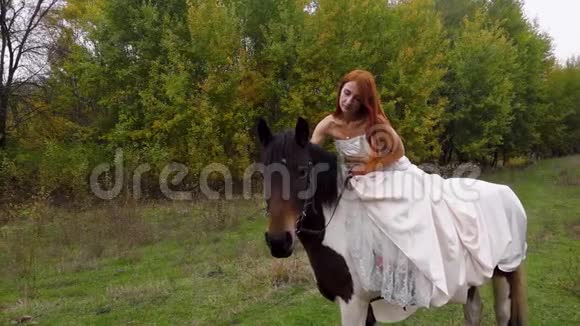 红头发的女人穿着米色连衣裙骑马关门视频的预览图