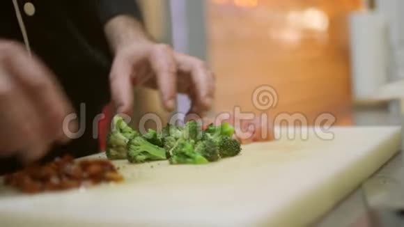 厨师用干西红柿和切碎的火鸡肉准备西兰花视频的预览图