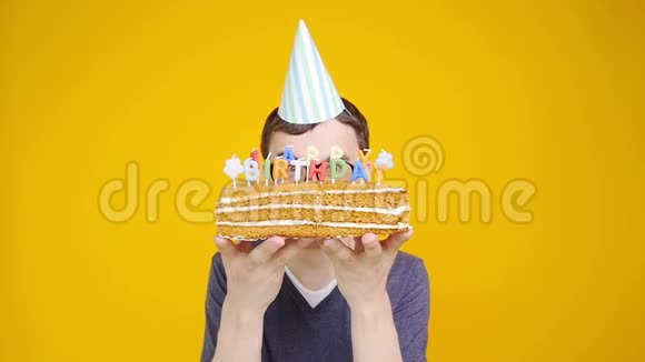 生日快乐带着橙色背景的蛋糕的年轻人视频的预览图