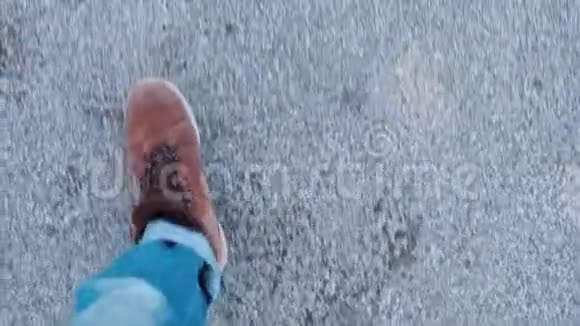 一个穿着冬靴的人在路上行走的腿的特写视频的预览图