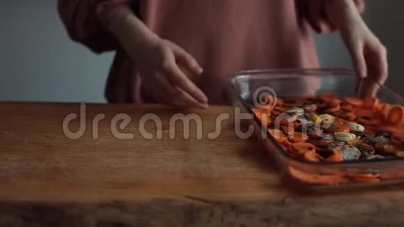 厨房里的一个女孩把切碎的胡萝卜和香料和酱汁混合在一个大玻璃碗里特写视频的预览图