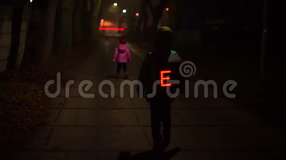 带着一个发光背包的小学生正在和他的妹妹一起走在路上视频的预览图