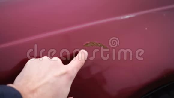 人在汽车油漆中表现出生锈的划痕手指显示红色汽车的划痕视频的预览图