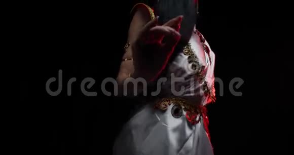穿着白色连衣裙的年轻印度女人在黑色背景下跳舞4k视频的预览图