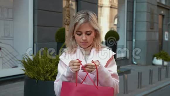 这位女士高兴地看到一个红色纸袋里的礼物高兴得跳了起来视频的预览图