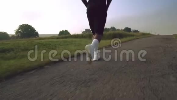 在绿茵场上的柏油路上奔跑的肌肉男视频的预览图