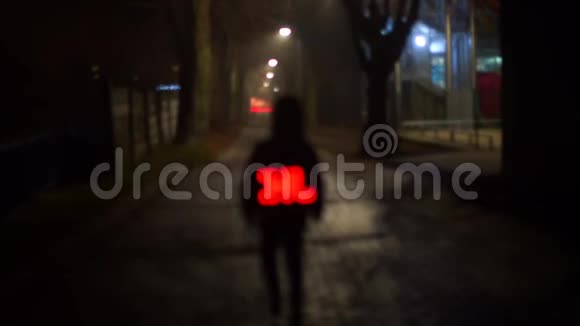 夜晚的孩子背着一个发光的背包在学校的道路上行走视频的预览图
