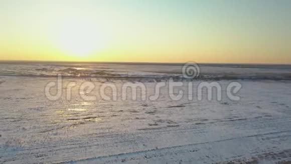日落时分火车正驶过白雪覆盖的田野视频的预览图