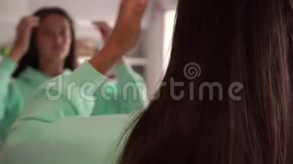 少女梳头在大浴室镜子里反射视频的预览图