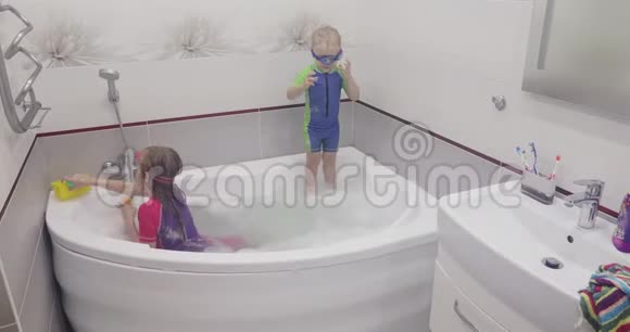 小男孩戴着蓝色的游泳眼镜正在洗澡时跳到水里视频的预览图
