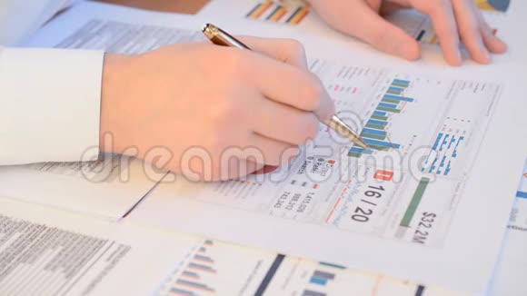 用笔在办公室办公分析图表和利润报告密切一位商人的关系视频的预览图