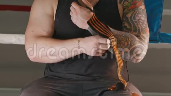 一个肌肉发达的男人用弹力绷带覆盖他的手腕视频的预览图