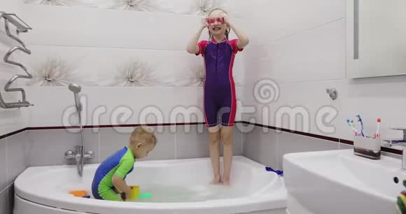一个戴着粉红色游泳眼镜的女孩正在洗澡时跳到水里视频的预览图