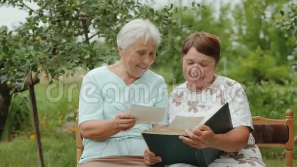 老年妇女在户外相册中观看照片视频的预览图