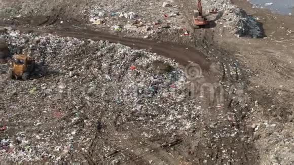 城市垃圾推土机沿着垃圾填埋场移动平整垃圾以食物为食的海鸥飞过它空中飞行视频的预览图