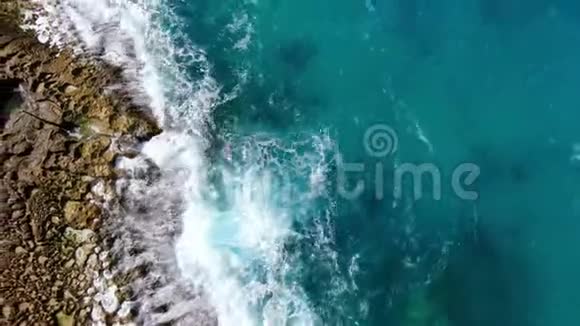 奇妙的土耳其蓝色海水撞击岩石从上往下看视频的预览图