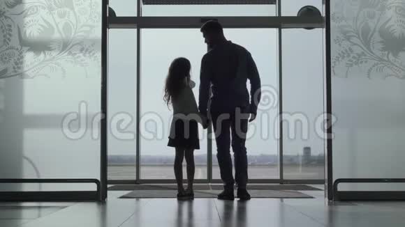 小白种人女孩的背面轮廓显示她父亲的机场跑道年轻人和女儿在等视频的预览图