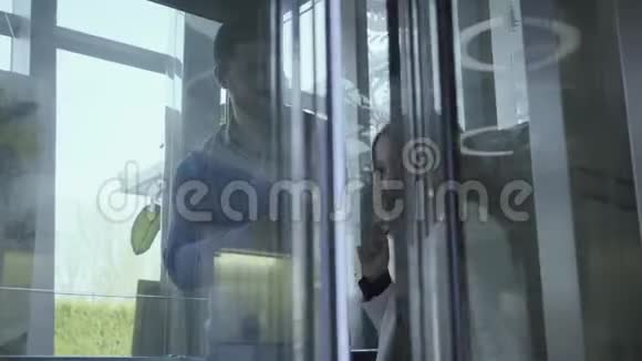 玻璃门的电梯服装和快乐的小白种人女孩骑上她的父亲在里面自信的高加索人视频的预览图