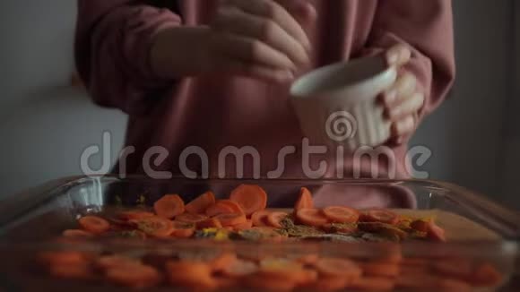 一个年轻女人的手在厨房里放了一盘切碎的胡萝卜特写视频的预览图
