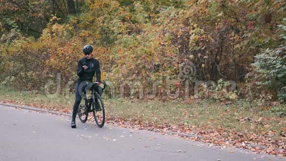 英俊的自行车手开始在秋天的城市公园骑公路自行车三项运动员骑在公路自行车上一个在布劳的男人视频的预览图