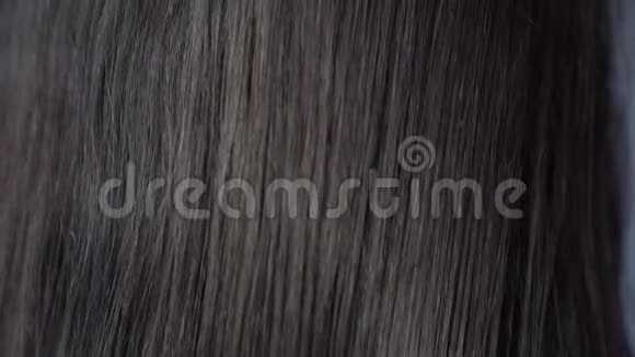 布鲁内特用紫色发刷把头发梳在头后视频的预览图