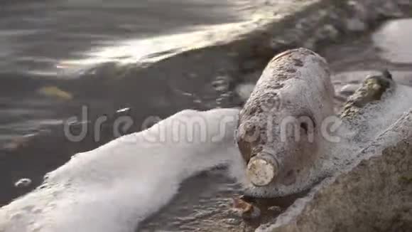 一个塑料瓶在水库岸边的波浪上摆动的特写镜头视频的预览图