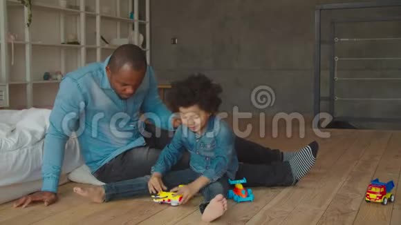 非洲父子在地板上玩玩具视频的预览图