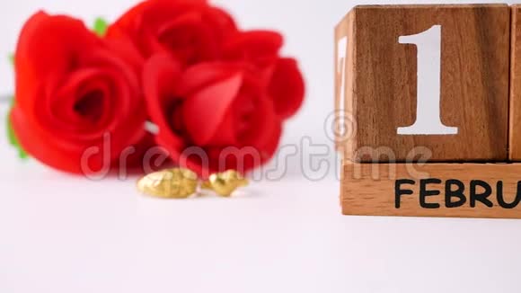 2月14日情人节当天用红玫瑰花束结婚戒指和木制日历庆祝白色背面隔离视频的预览图