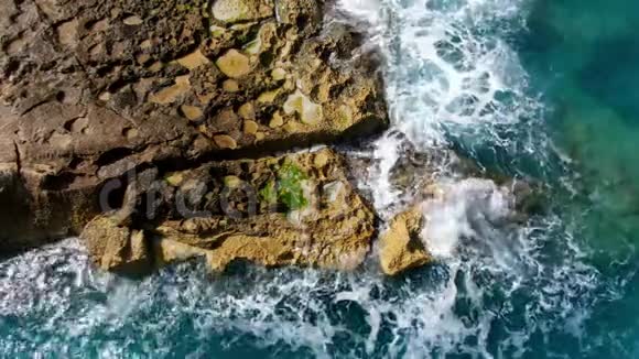奇妙的蓝绿色海水撞击岩石从上往下看视频的预览图