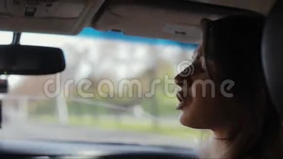 漂亮的女人坐在车里她看着窗外转过头和司机说话开车旅行视频的预览图