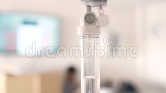 医院模糊豪华贵宾室背景下患者和输液泵盐水滴液的特写视频的预览图