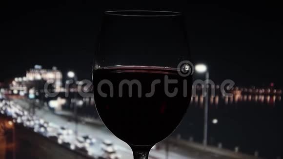 在离焦的黑暗背景上挥舞红酒夜城生活视频的预览图
