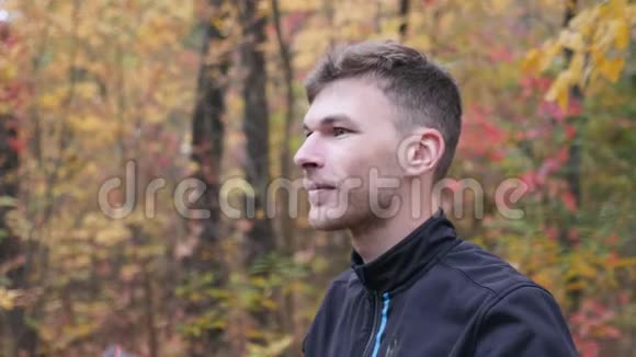 男性自行车手健康的年轻职业运动员在秋季公园训练前戴上黑色自行车头盔动机视频的预览图
