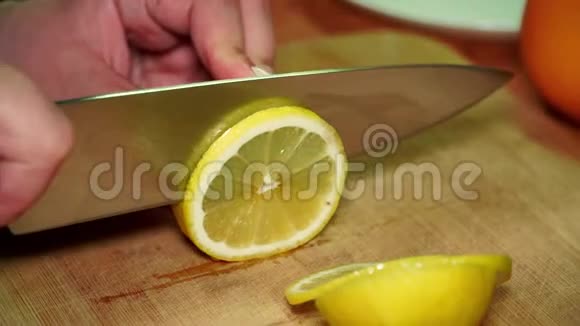 一个女孩在木板上用刀切开一个多汁的成熟维生素黄柠檬视频的预览图