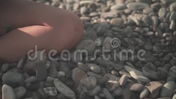 紧紧抓住一个女人的手捡起一块石头然后把它从海滩上的手掌上扔下来视频的预览图