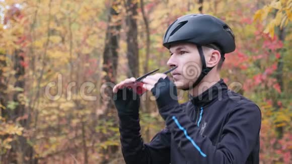 职业男性骑自行车的黑色运动服装和头盔准备在秋季公园训练和戴上眼镜骑自行车视频的预览图