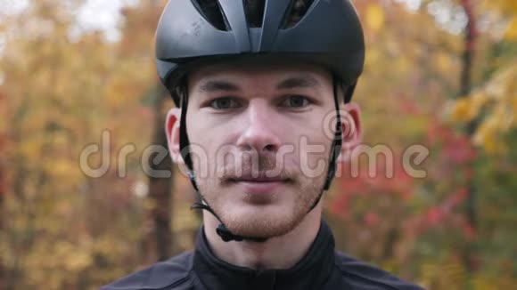 秋天美丽森林中年轻职业自行车手的肖像戴着运动眼镜的男性脸部特写镜头视频的预览图