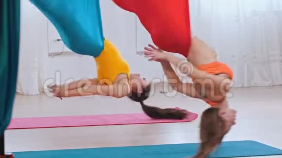 两个女人在空中瑜伽吊床上旋转视频的预览图