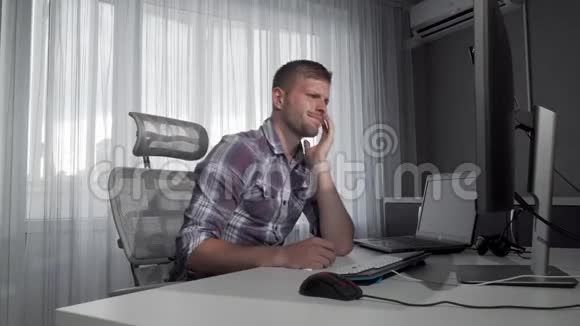 坐在电脑前的男自由职业者视频的预览图
