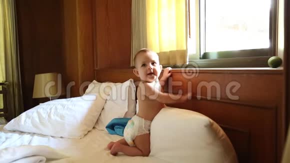 一个笨手笨脚的快乐小宝宝在床上爬行学会了起来走路视频的预览图