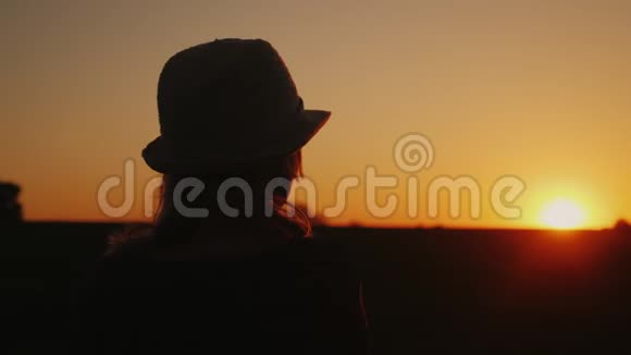 一个戴着帽子的孤独女人看着夕阳后景梦想和规划一个概念视频的预览图