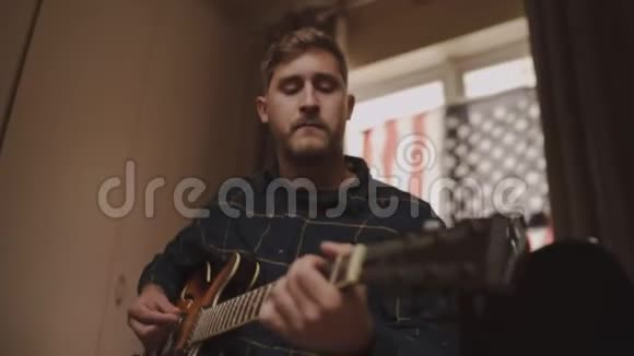 一个年轻人在家里玩声吉他的空闲时间的画像视频的预览图
