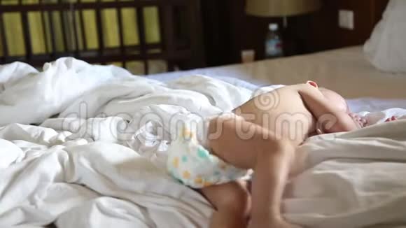 饥饿的婴儿在床上翻滚吮吸手指视频的预览图