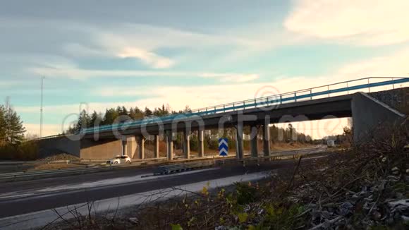 美丽的斯堪的纳维亚风景高速公路上有超速行驶的汽车绿林和蓝天背景时光流逝视频的预览图