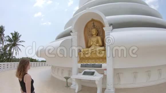 白人女孩在佛陀面前祈祷视频的预览图