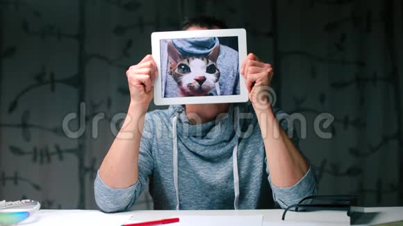 一个人手里拿着一块平板电脑手里拿着一只猫视频的预览图